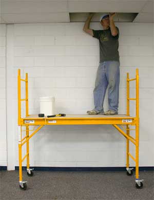 Man Repairing Ceiling While Standing on Scaffolding